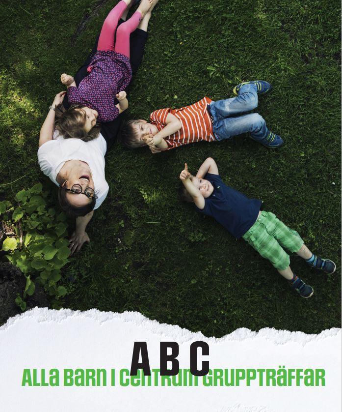 Tre barn och en vuxen ligger på en gräsmatta