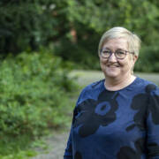 MIELI ry:n asiantuntija Sirkkaliisa Heimonen hymyilee ja katsoo suoraan kameraan ulkona puistossa.