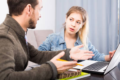 Kaksi henkilöä neuvottelee tietokoneen ääressä