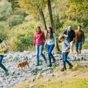 Ryhmä ihmisiä ja koira kävelee luonnossa