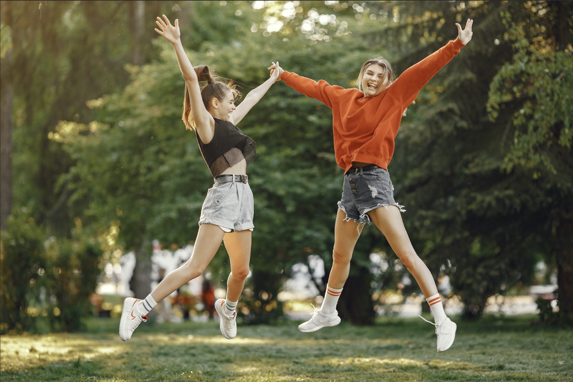 Kaksi tyttöä hyppää ilmaan