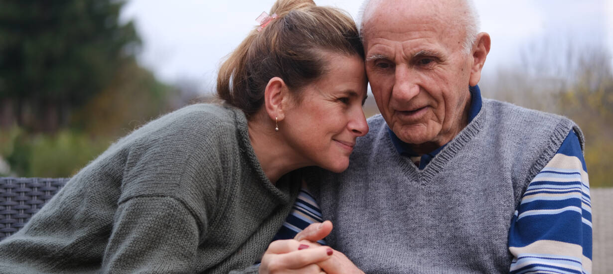 Vanhempi mies ja nainen istuvat penkillä