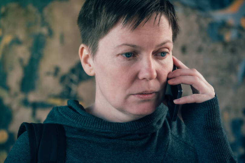 Vakavailmeinen nainen puhelimessa