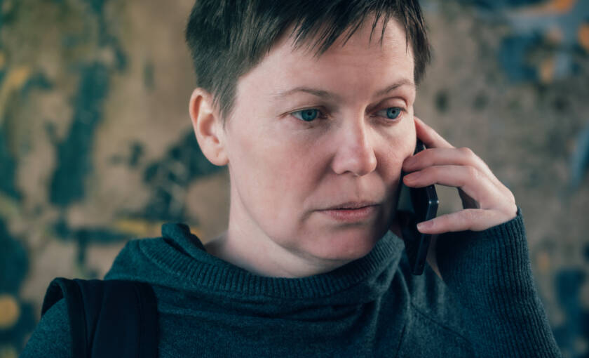 Vakavailmeinen nainen puhelimessa