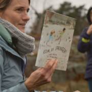 Kvinna visar fram en barnbok