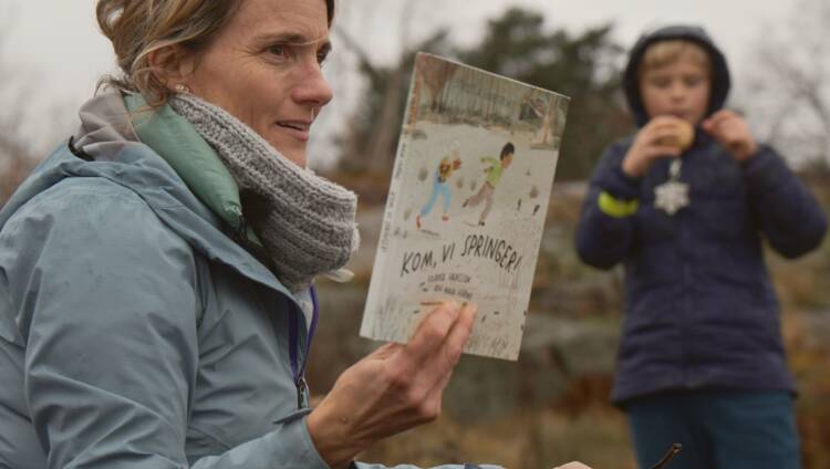 Kvinna visar fram en barnbok