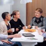Työporukka istuu kahvihuoneessa