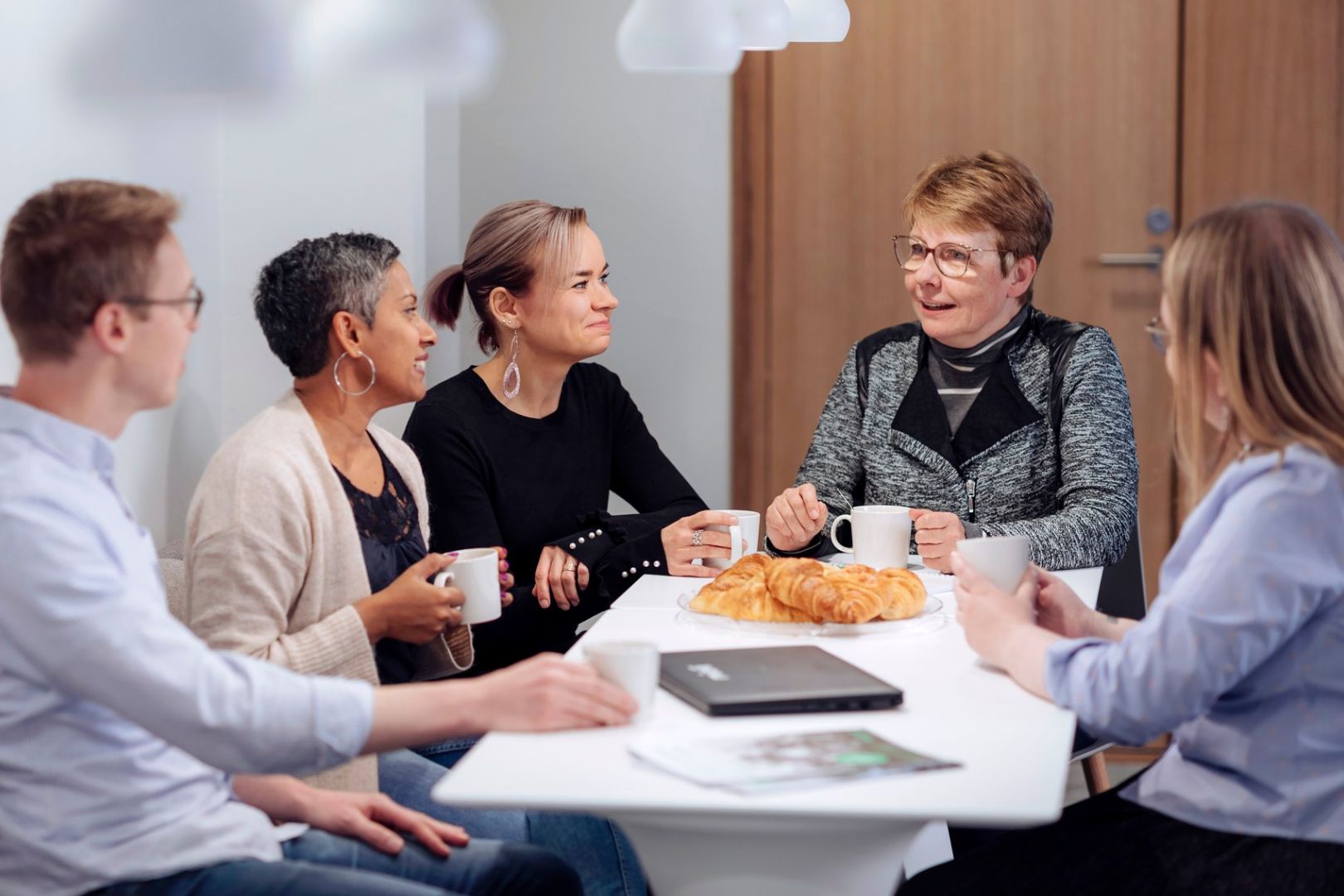 Työporukka istuu kahvihuoneessa