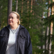 Nainen metsässä, katselee sivuun